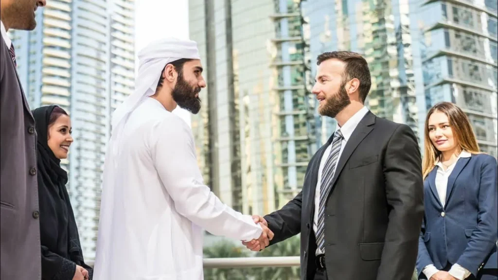 Business professionals shaking hands in Dubai with modern skyscrapers in the background, symbolizing successful marketing and branding partnerships for digital marketing agency in the UAE