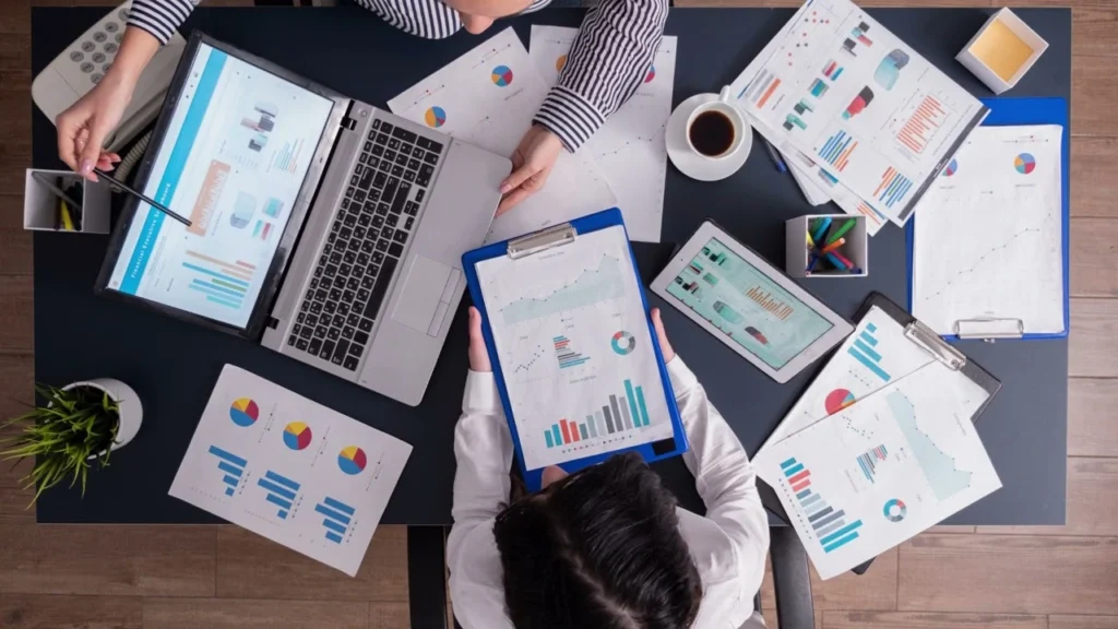 Team at Dubai Marketing Agency analyzing marketing reports, charts, and KPIs during a strategy meeting.