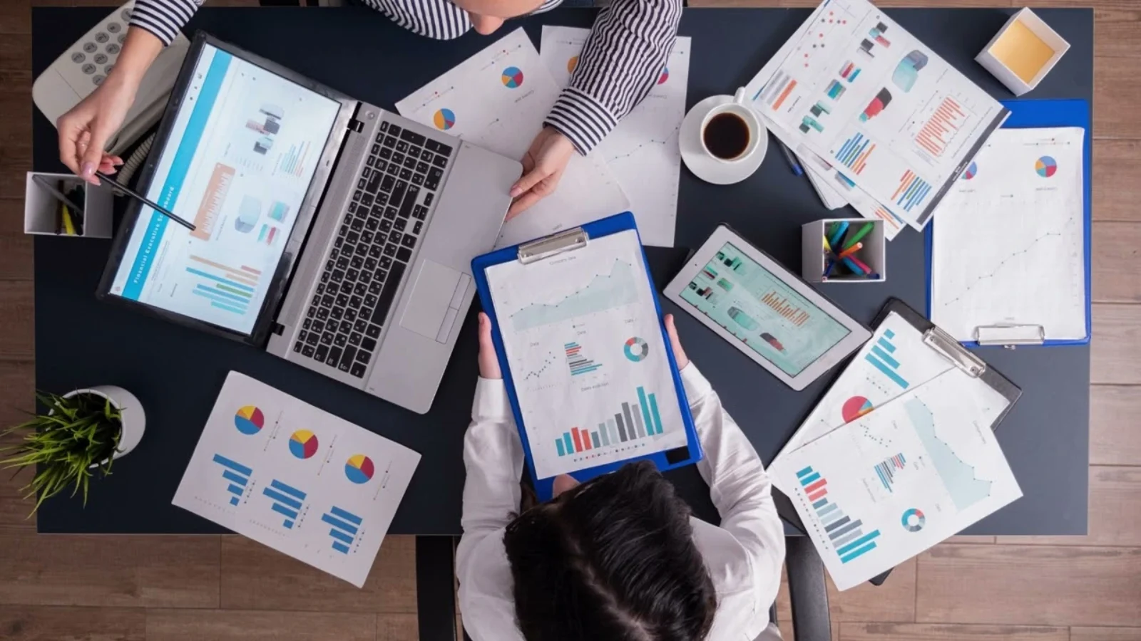 Team at Dubai Marketing Agency analyzing marketing reports, charts, and KPIs during a strategy meeting.
