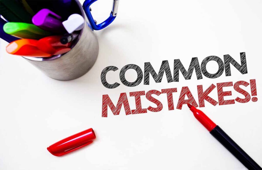 Text "COMMON MISTAKES!" written with a red marker next to colorful pens on a white surface.